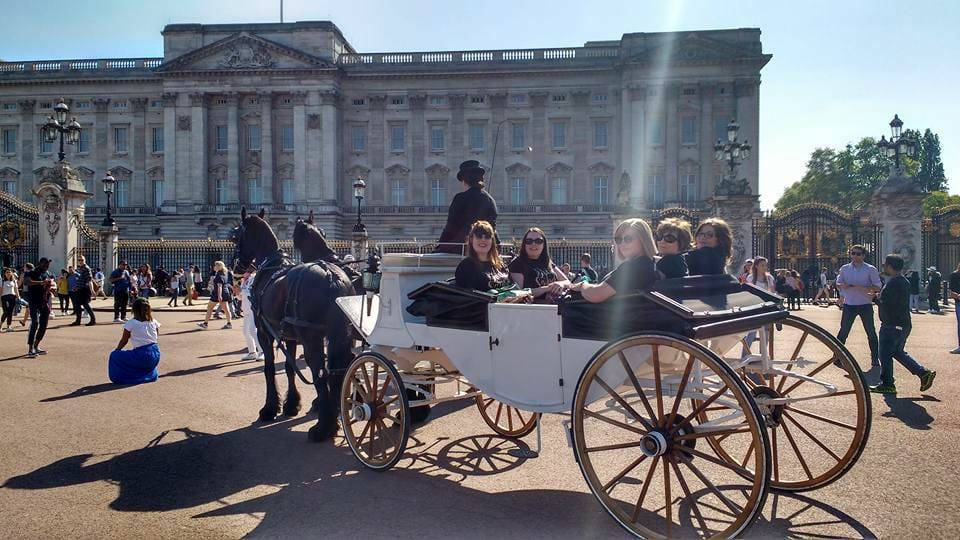 A horse drawn carriage in front of Buckingham Palace