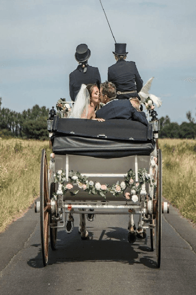 A wedding carriage seen from behind on a country road
